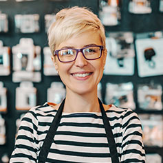 woman with glasses smiling and staring at camera